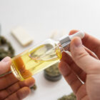 bottle of oil Cannabis in pipette in hand, hemp product, CBD cannabis OIL on white background, close up, medical marijuana concept,