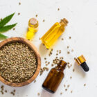 Cannabis oil and cannabis seeds at white.